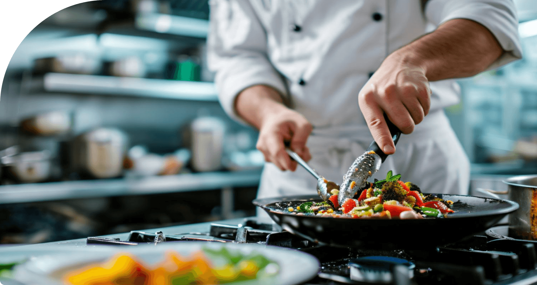 na zdjęciu kucharz przygotowujący potrawę w restauracji